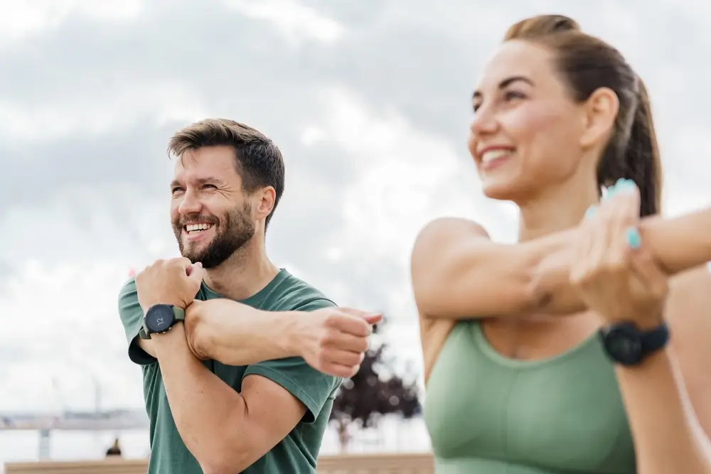 two friends in fitness clothing stretching together